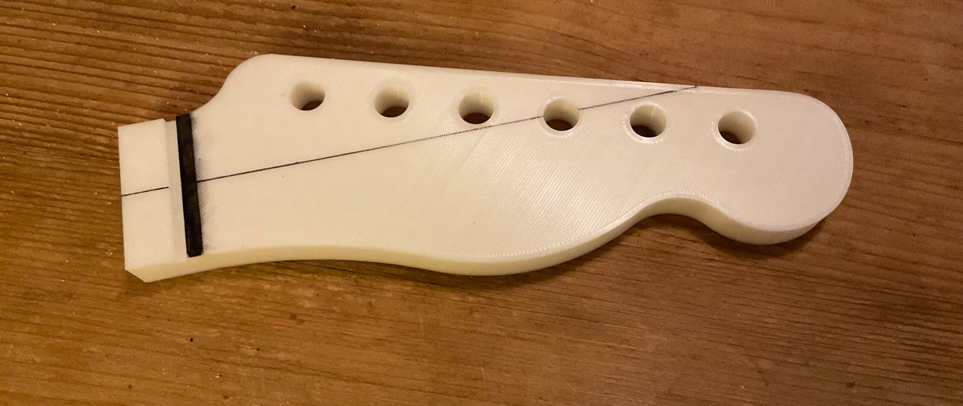 Eine 3d gedruckte Schablone einer Kopfplatte einer elektrischen Gitarre.